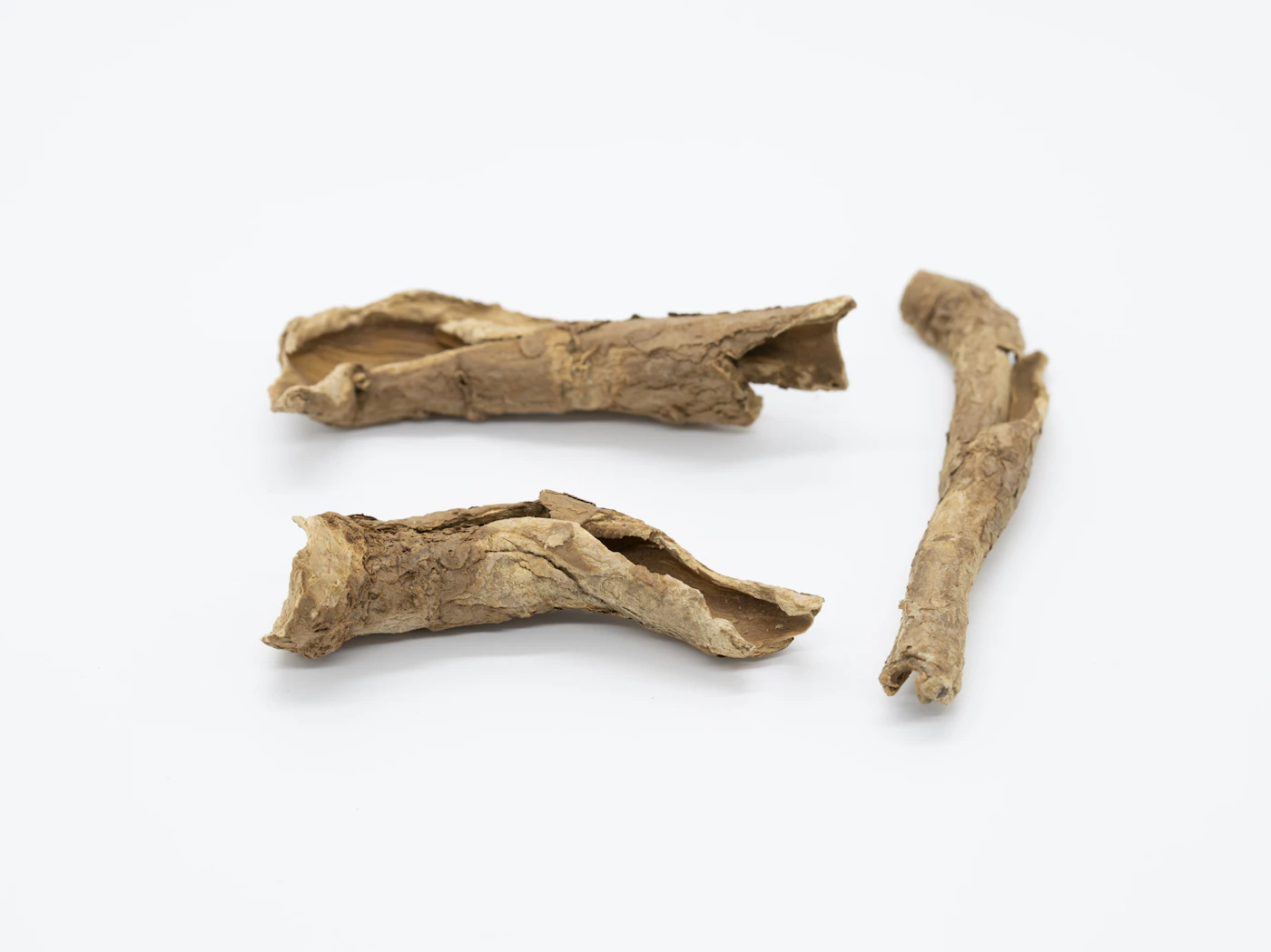 Pieces of dried licorice root (Gan Cao) on a white background